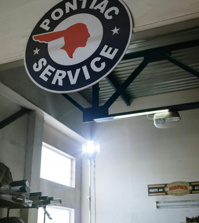 Classic Pontiac service sign hanging in a retro car garage.